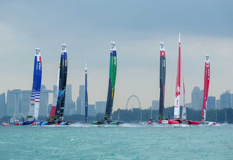 The F50 fleet races towards the start line on Race Day 2 with the Marina Bay Sands Hotel and the city skyline behind themof the Singapore Sail Grand Prix presented by the Singapore Tourism Board in Singapore, Singapore. 15th January 2023. Photo: Bob Martin for SailGP. Handout image supplied by SailGP